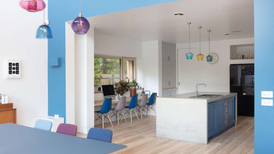 blue and white kitchen with colourful glass handing ceiling lights above an island