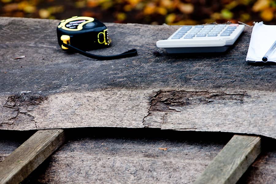 tape measure and calculater laying on felled oak board