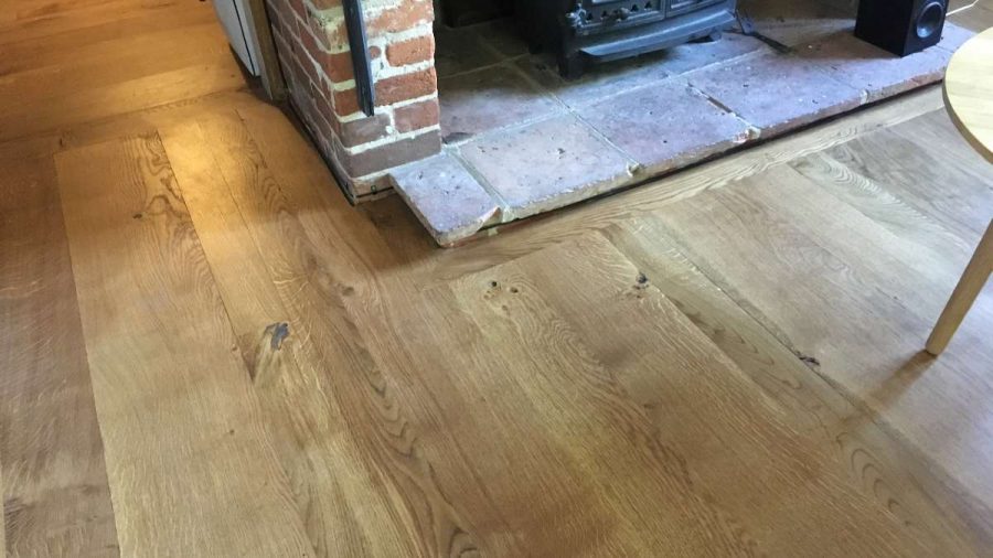 wood flooring with clay pantile fireplace with base of wood burner