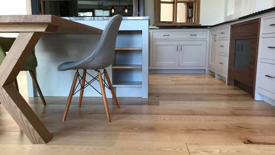 ash flooring in kitchen with pale blue cabinets and pale blue chair