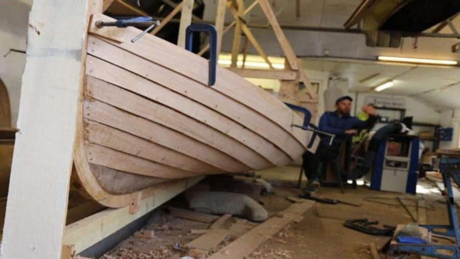 wooden boat being repaired in workshop