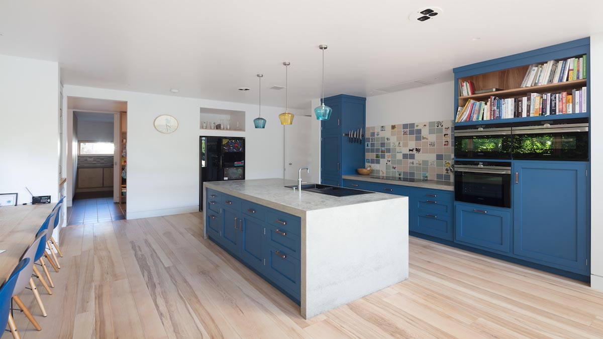 light ash flooring in kitchen with island and cupboards and bookshelf