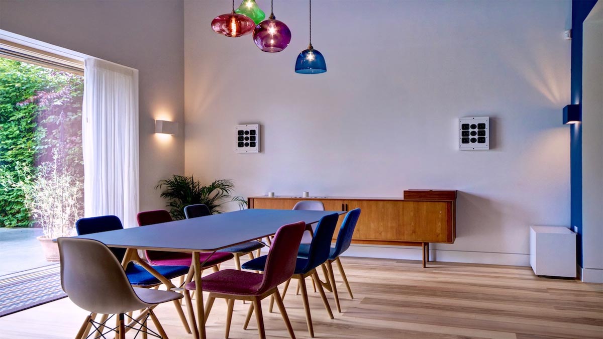 blue dining table in room with side board and wall speakers