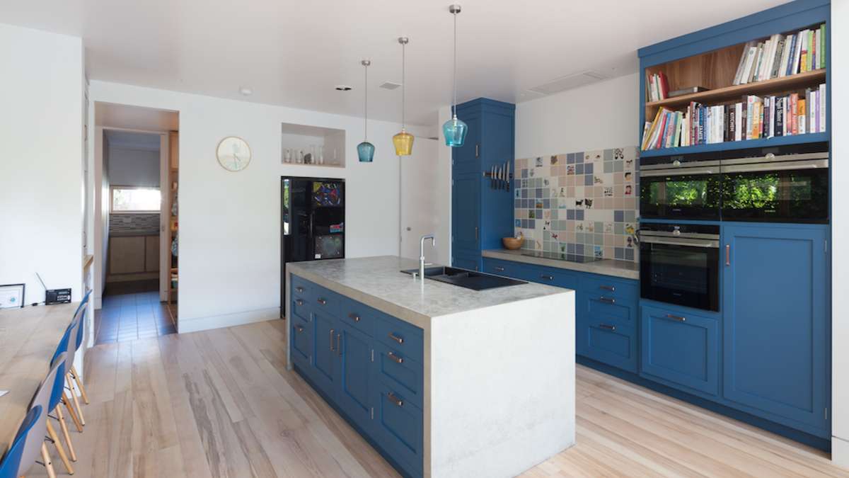 blue kitchen cabinetry in kitchen with pale timber flooring