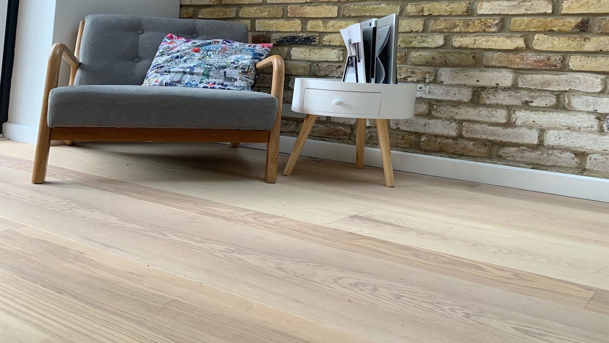 ash flooring with easy chair and brick wall