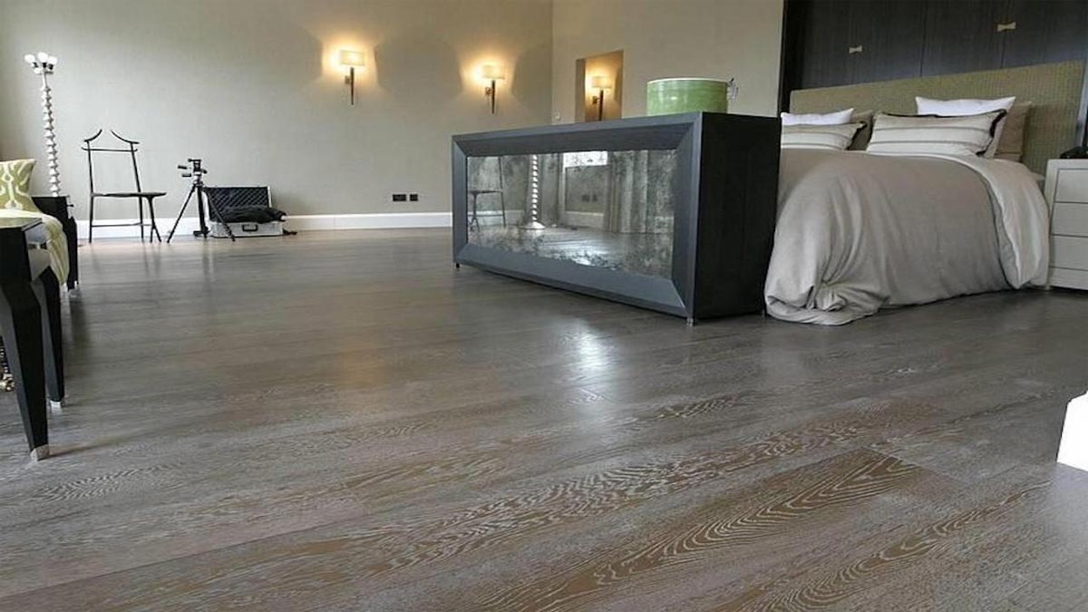 grey oak flooring in bedroom with double bed and mirrored footboard