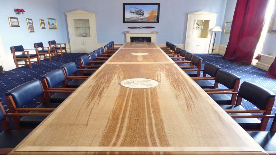 large oak boardroom table and chairs with blue patterned carpet