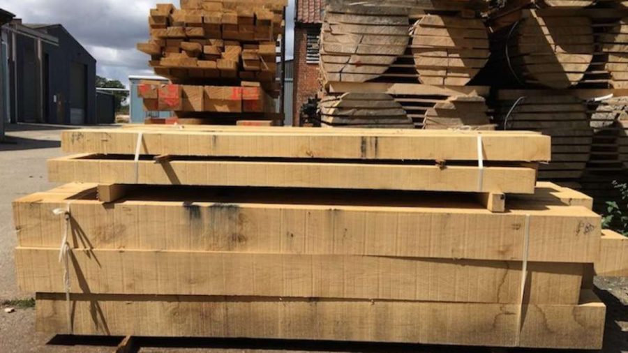 stack of cut beams in front of timber stick behind in timber yard