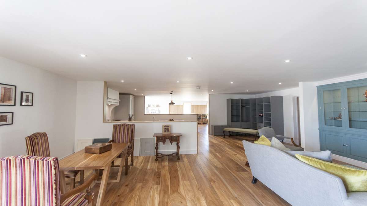 show room with elm flooring and dining table and sofa