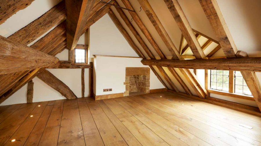 heavily oak beamed roof space with stone fireplace and metal windows