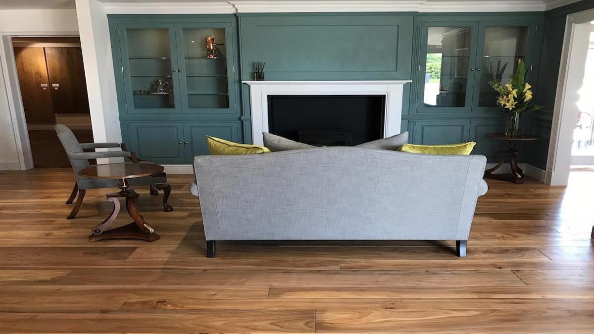 back of sofa by fireplace in room with green cabinetry