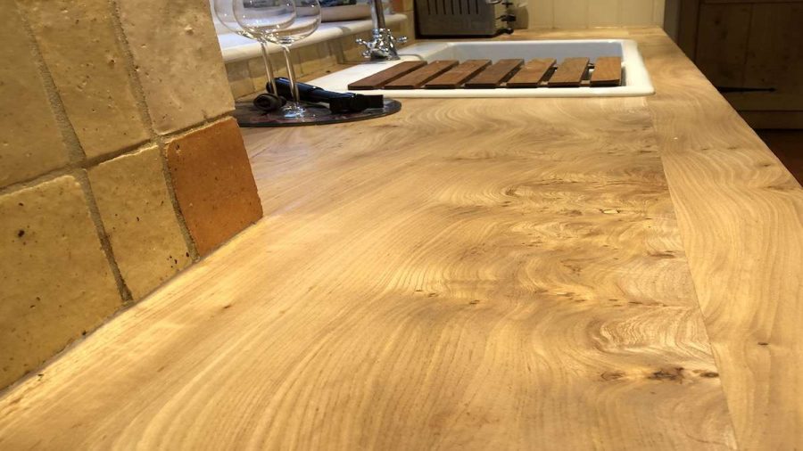 elm work surface in kitchen with drainer in view and wine glases