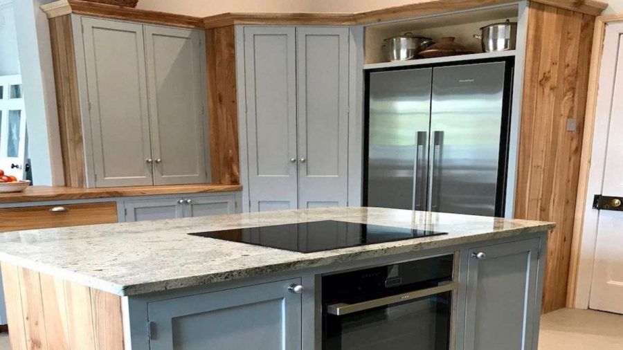grey kitchen cabinetry with island granite worktop and hob
