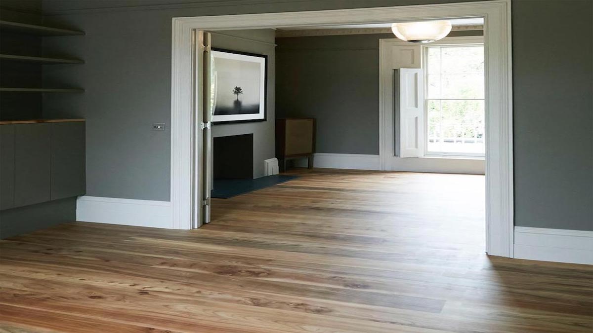 empty room with open doors leading to a window with elm flooring