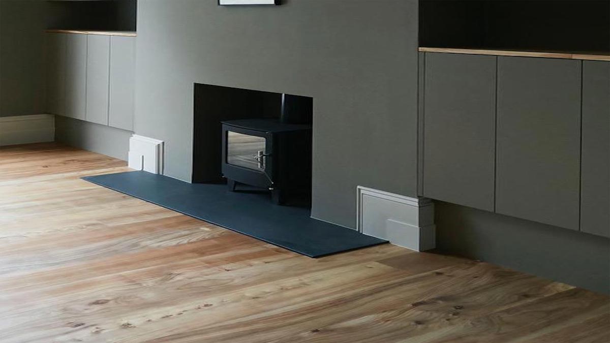 grey cupboards in room with modern wood burner