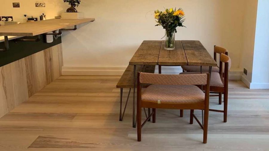 ash flooring in kitchen diner with rustic table and flowers in a vase