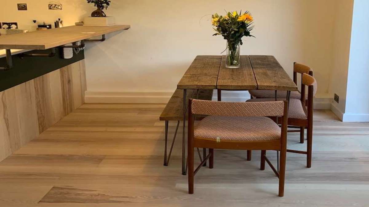 dining room with pale wood floor and table set with flowers