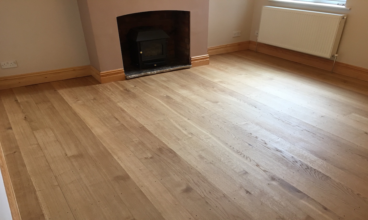 oak flooring with woodburner in fireplace and radiator on wall