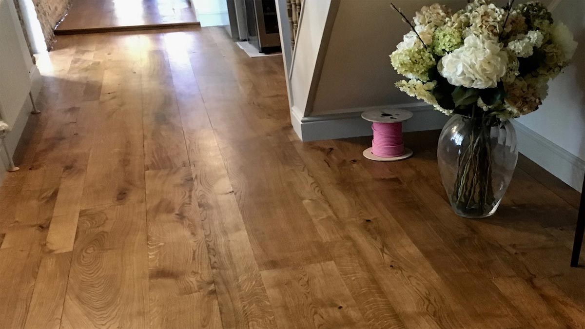 oak flooring with understairs view of huge vase of flowers