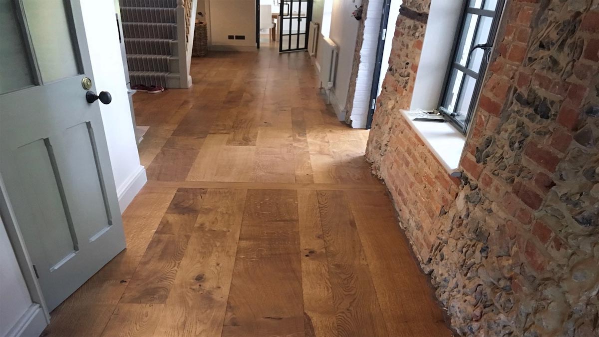 hallway of wood flooring and brick and flint walls